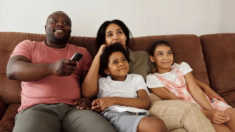 Família assistindo TV juntos na sala